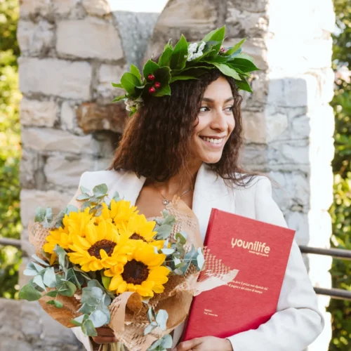 Corona di alloro con bacche rosse e fiori bianchi